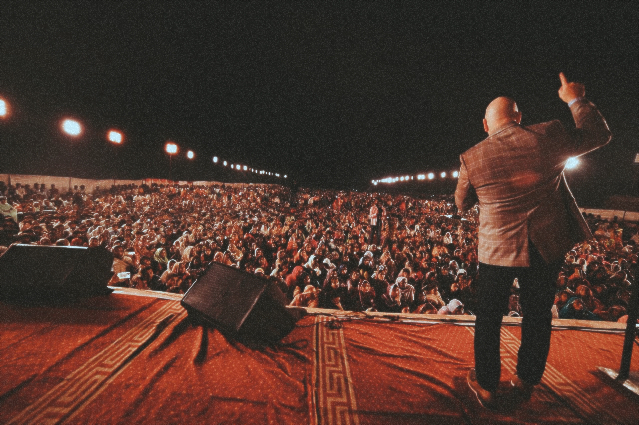 Pastor David on stage in Pakistan, preaching at a crusade in front of a crowd of tens of thousands