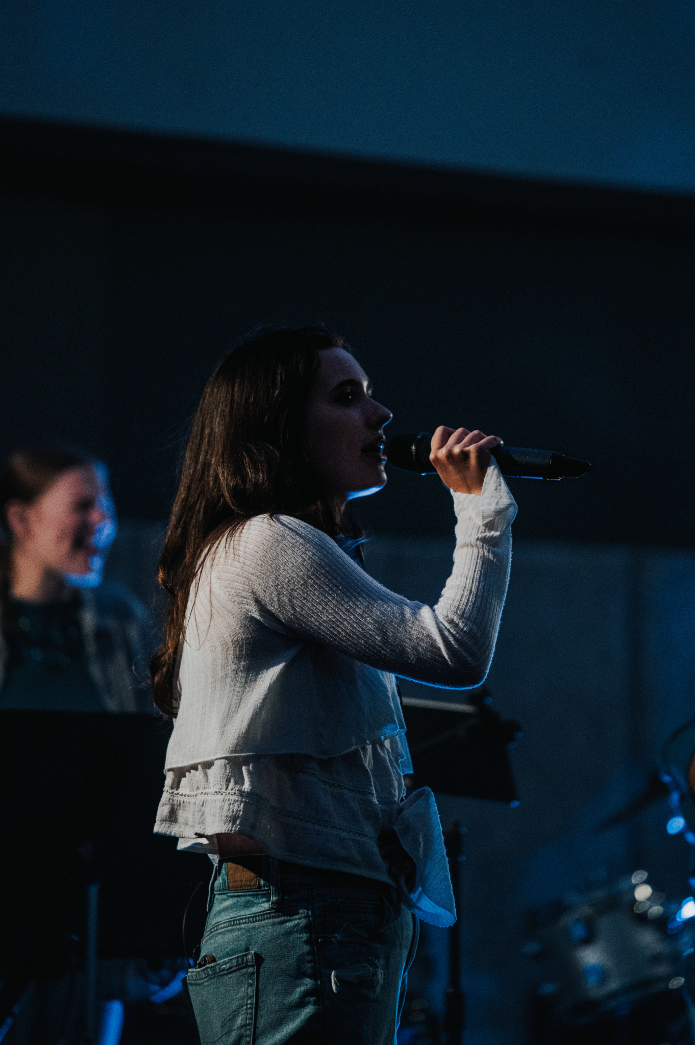A young woman leading worship for the youth group