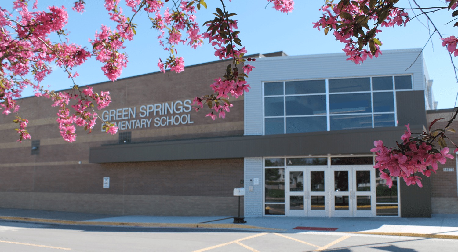 Green Springs Elementary exterior image in the spring, with trees in the forefront. 