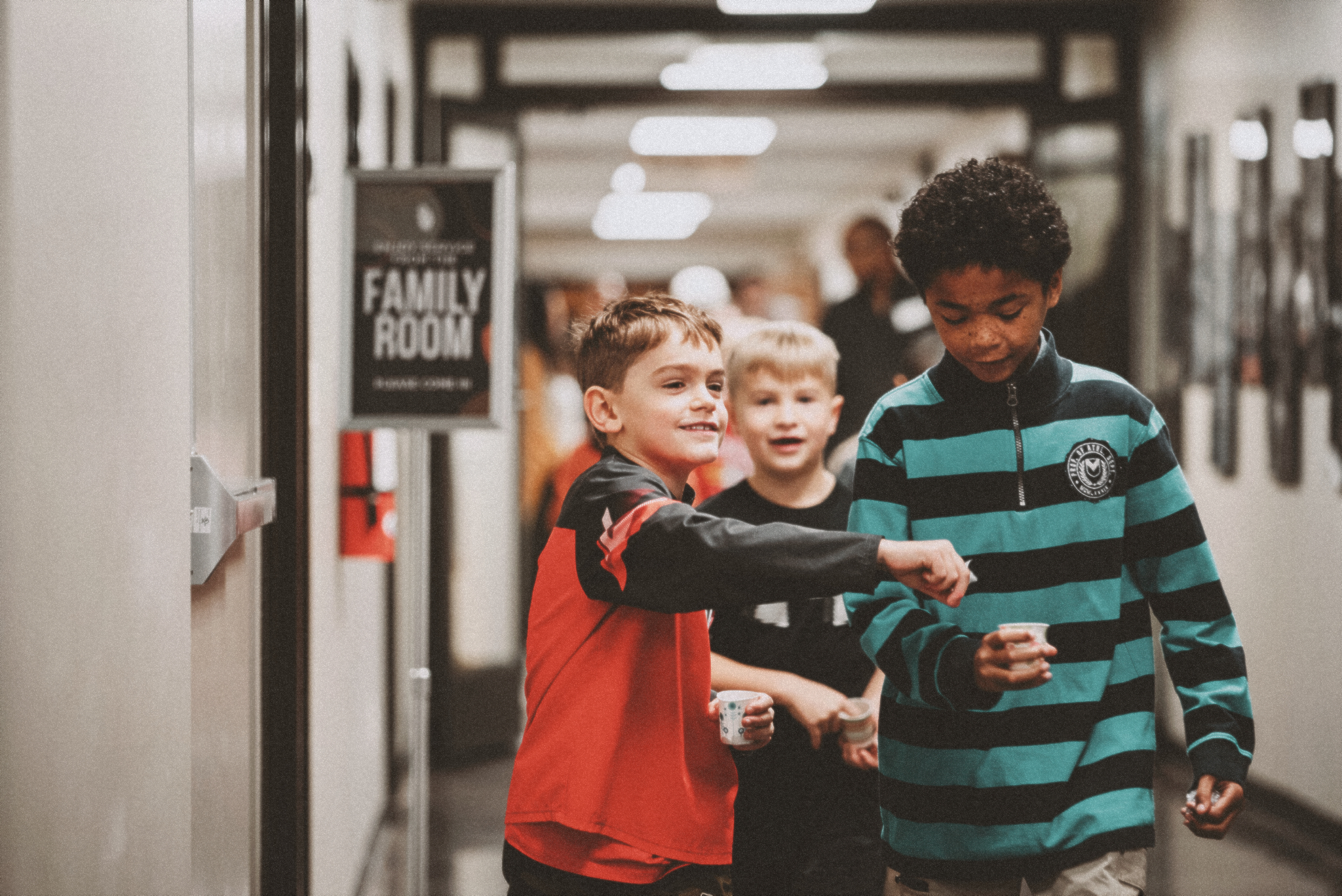 Three young boys walking together to Harvest Kids