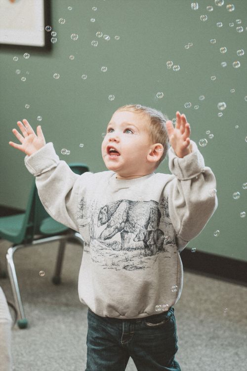 A little boy chasing bubbles