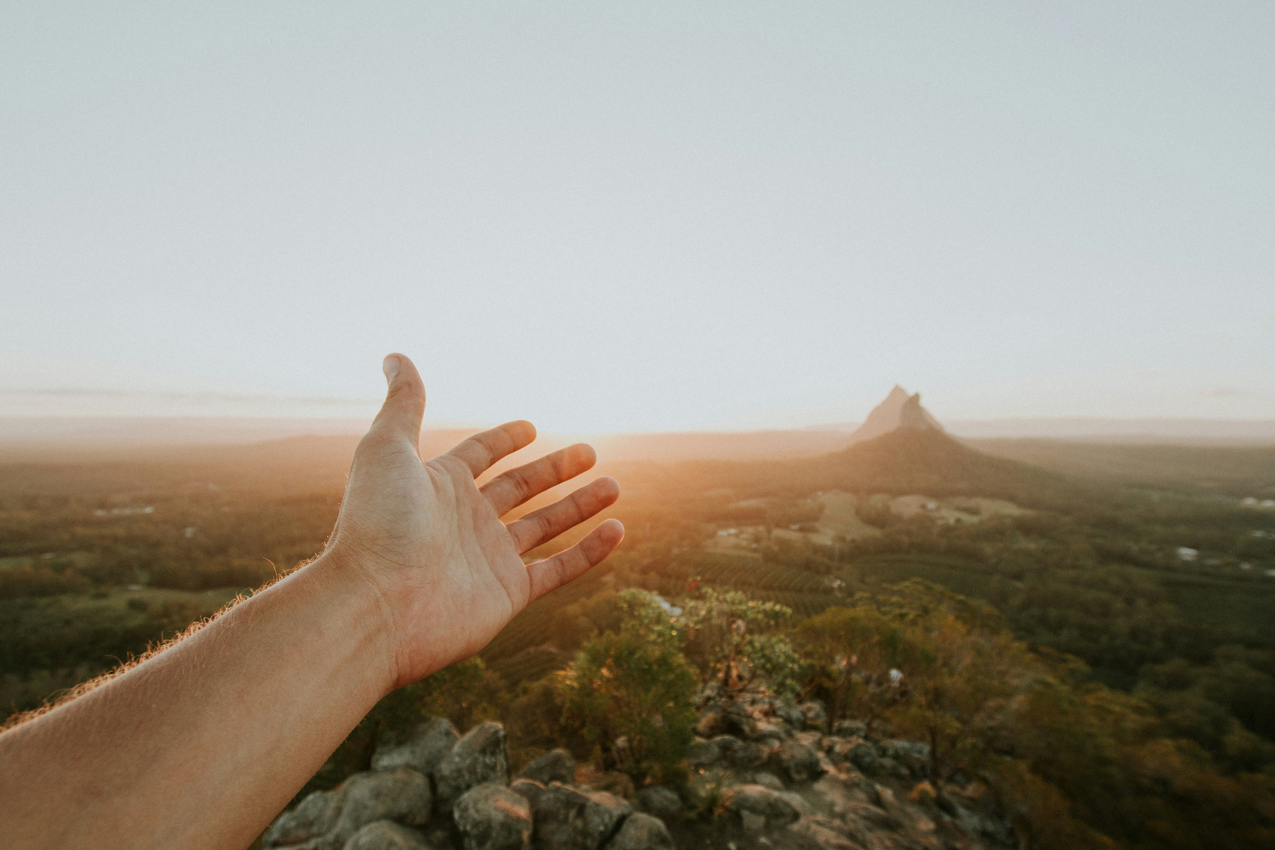 A hand outstretched to the mountains, represents the verse "therefore go and make disciples of all nations." 

Credit: cody-board-jORYUUvgfpA-unsplash