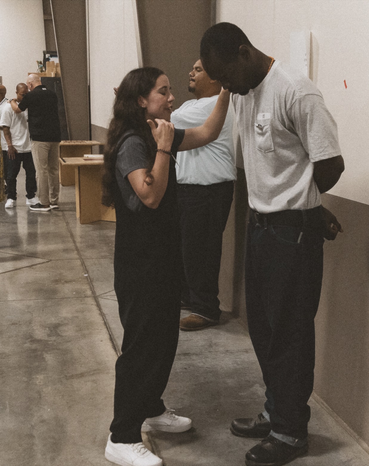 A young woman praying with a man at the prison outreach