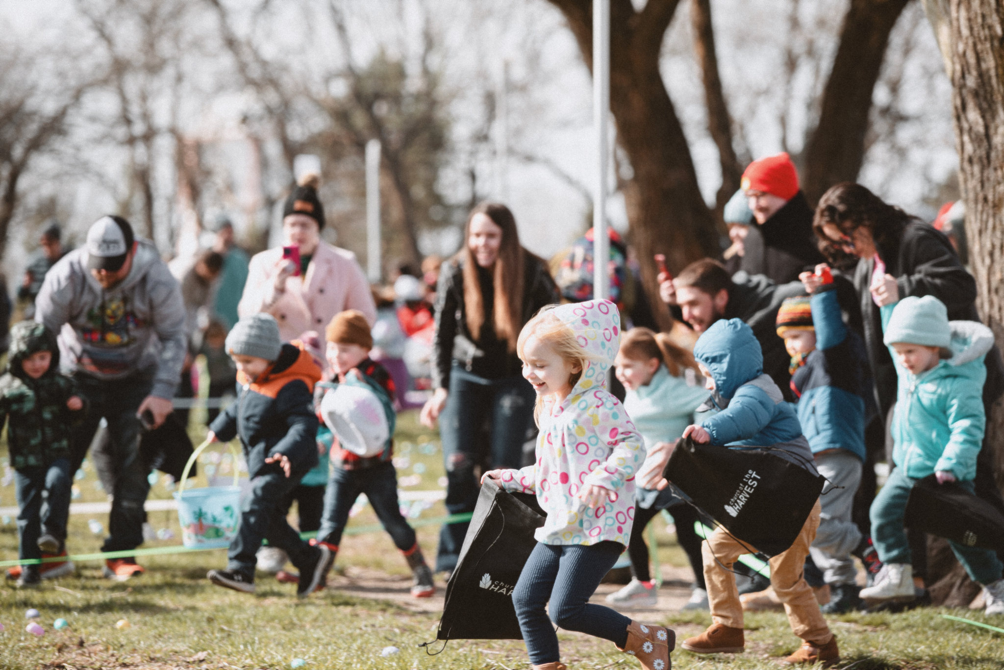 Image of young children racing to find Easter eggs at a COTH Easter Egg Hunt event. 