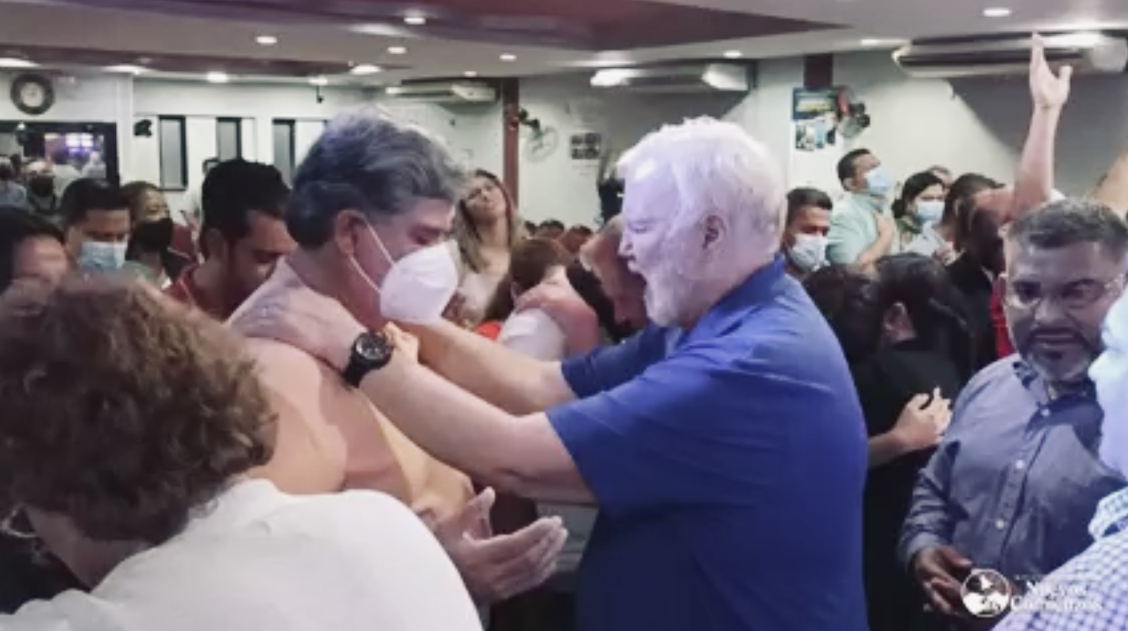 A church of the harvest team member praying over a man in a mask during a prayer meeting in Honduras