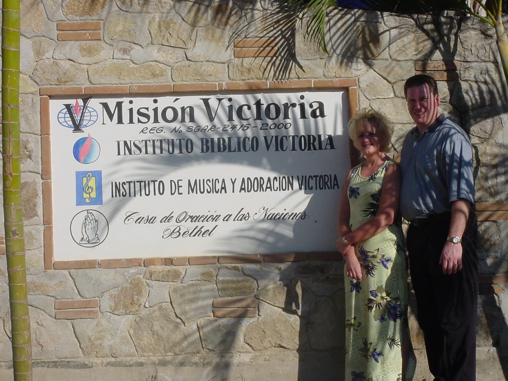 Pastor David and Tracy posing in front of a Bible Institute in Mexico