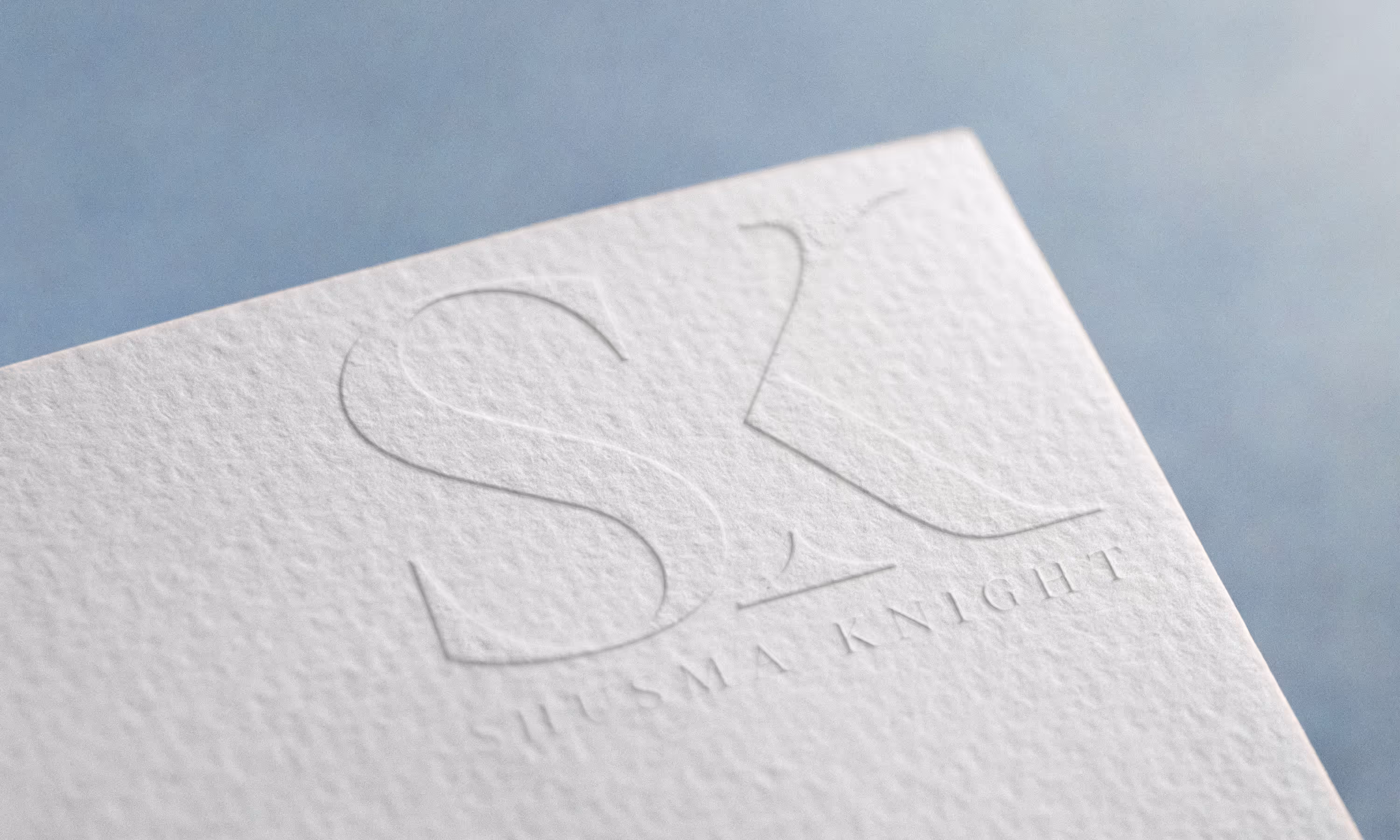An embossed card featuring the Shusma Knight logo 