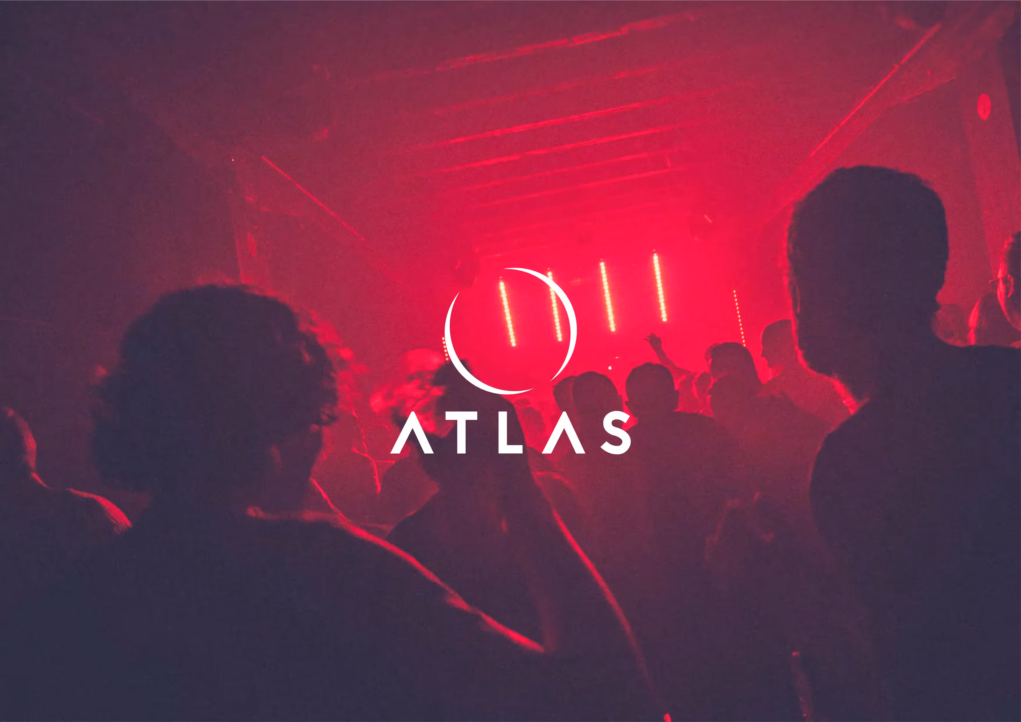 A pinky red light shines in a disco giving the people in the photo a silhouette look. The atlas logo is placed in the middle of the image in white.