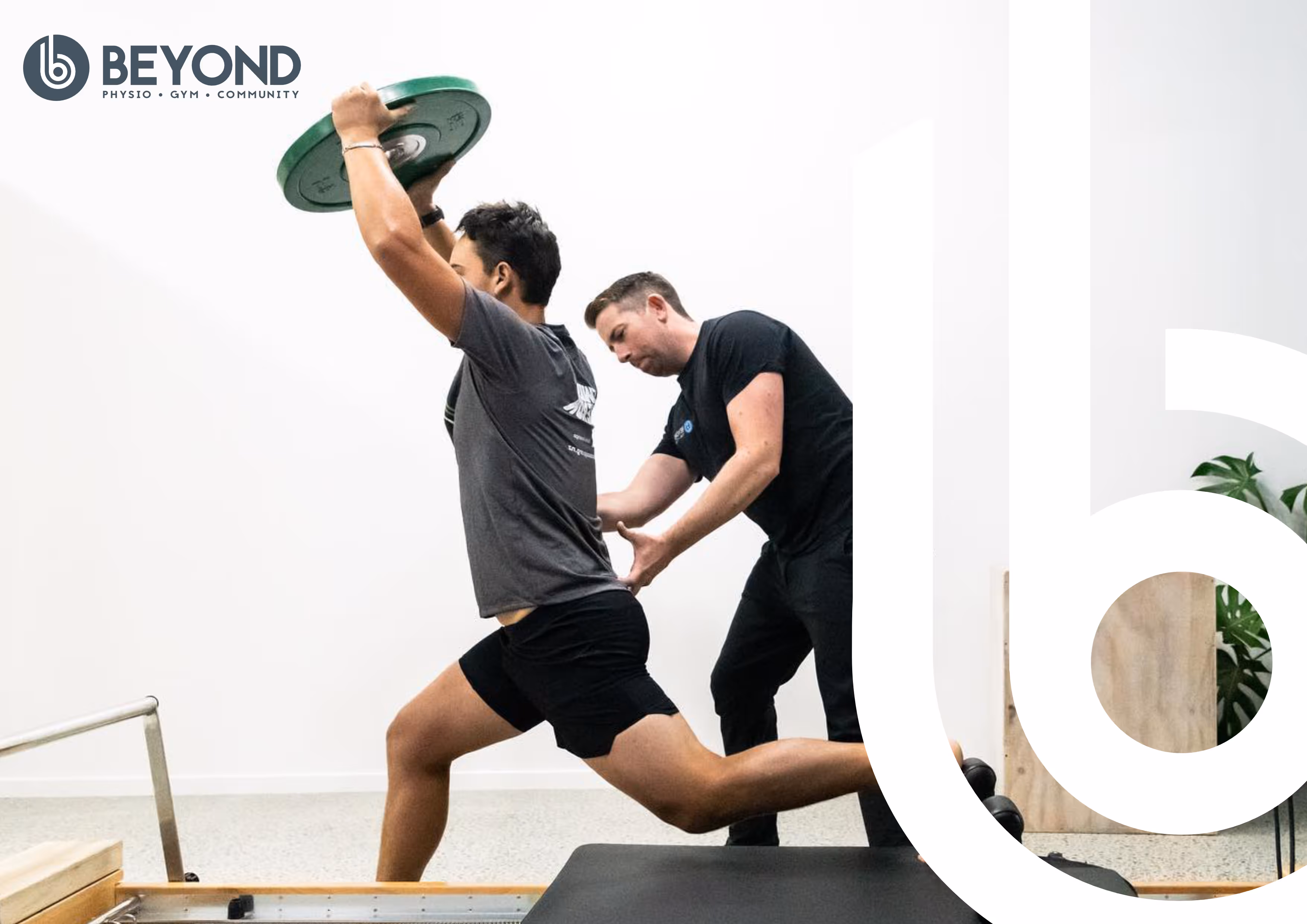 A physio helps an athletic man with strength training