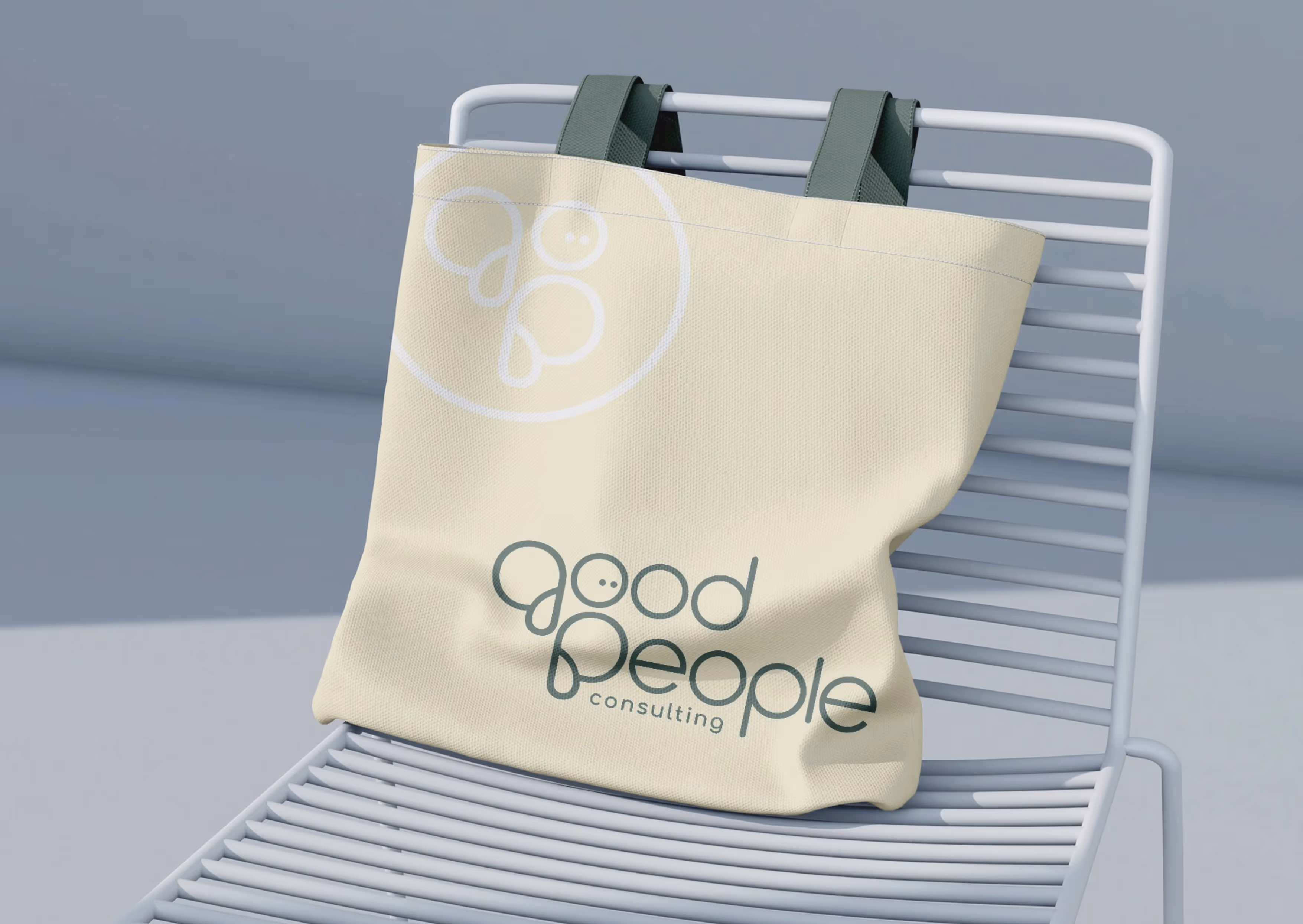 A tote bag draped on a chair featuring the good people branding