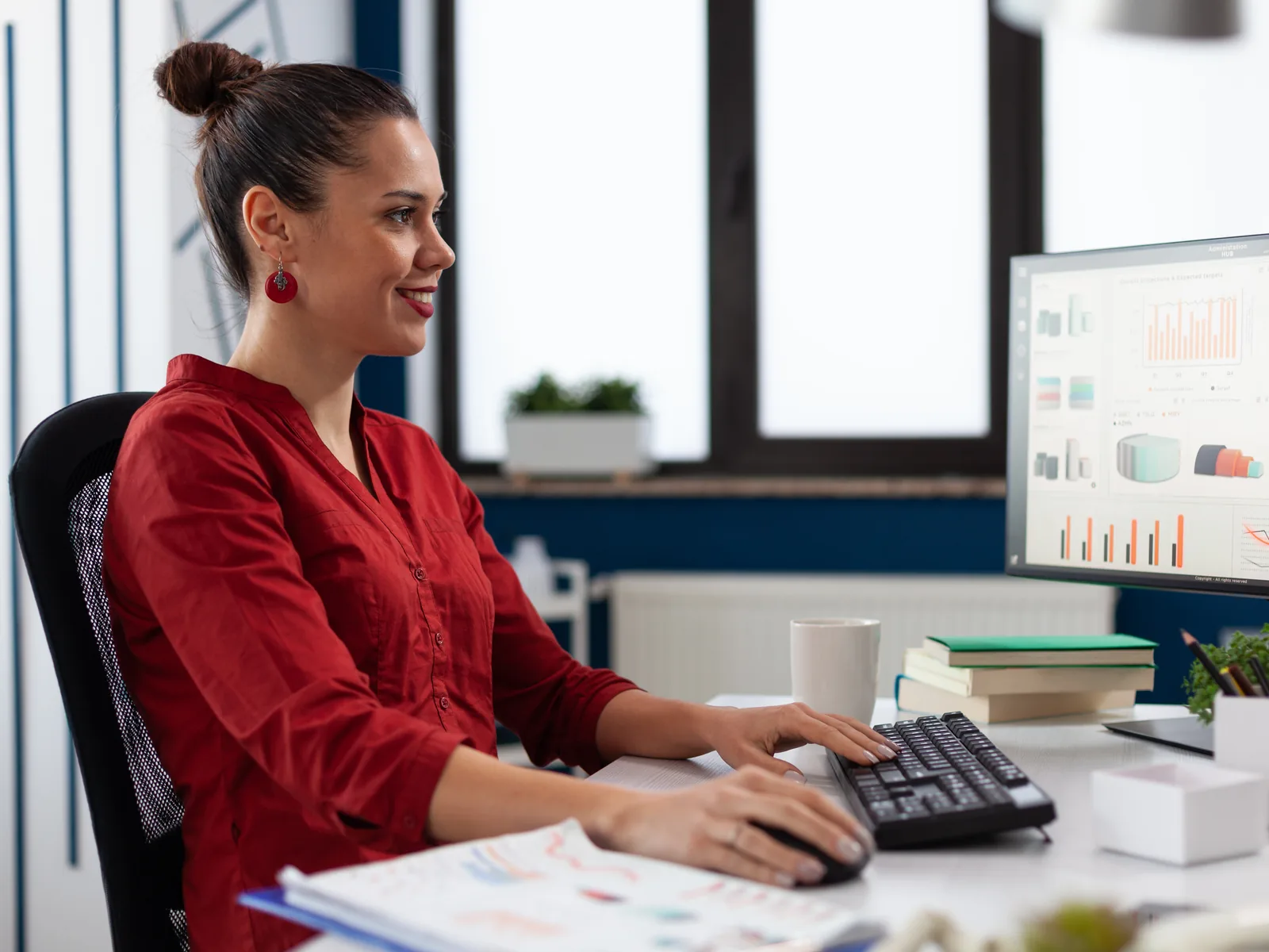 Marketer reviewing campaign performance charts on a desktop monitor in an office