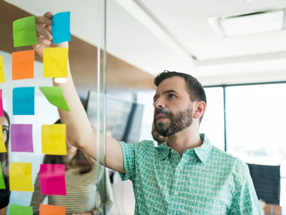 Marketing manager planning a campaign on sticky notes with the team