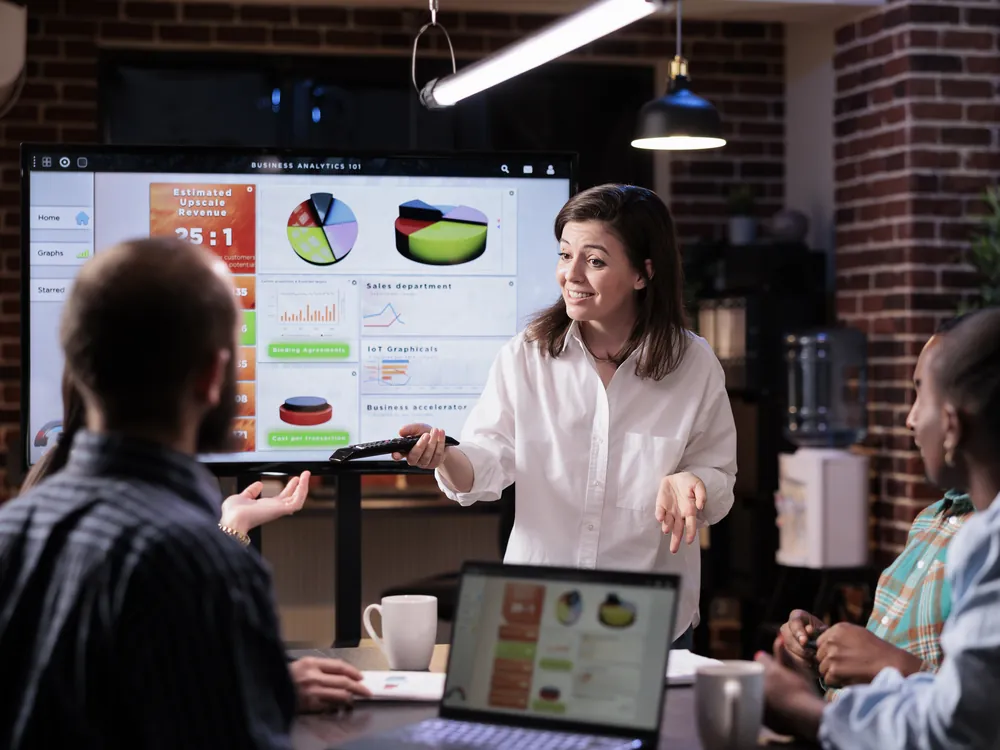 Marketer presenting campaign results on a large screen to the team