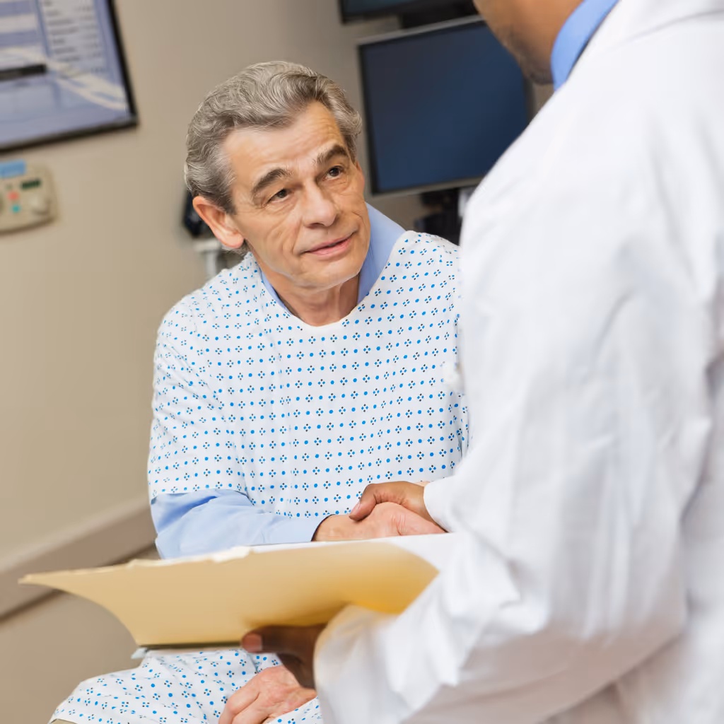 Senior patient in hospital shaking hands with doctor
