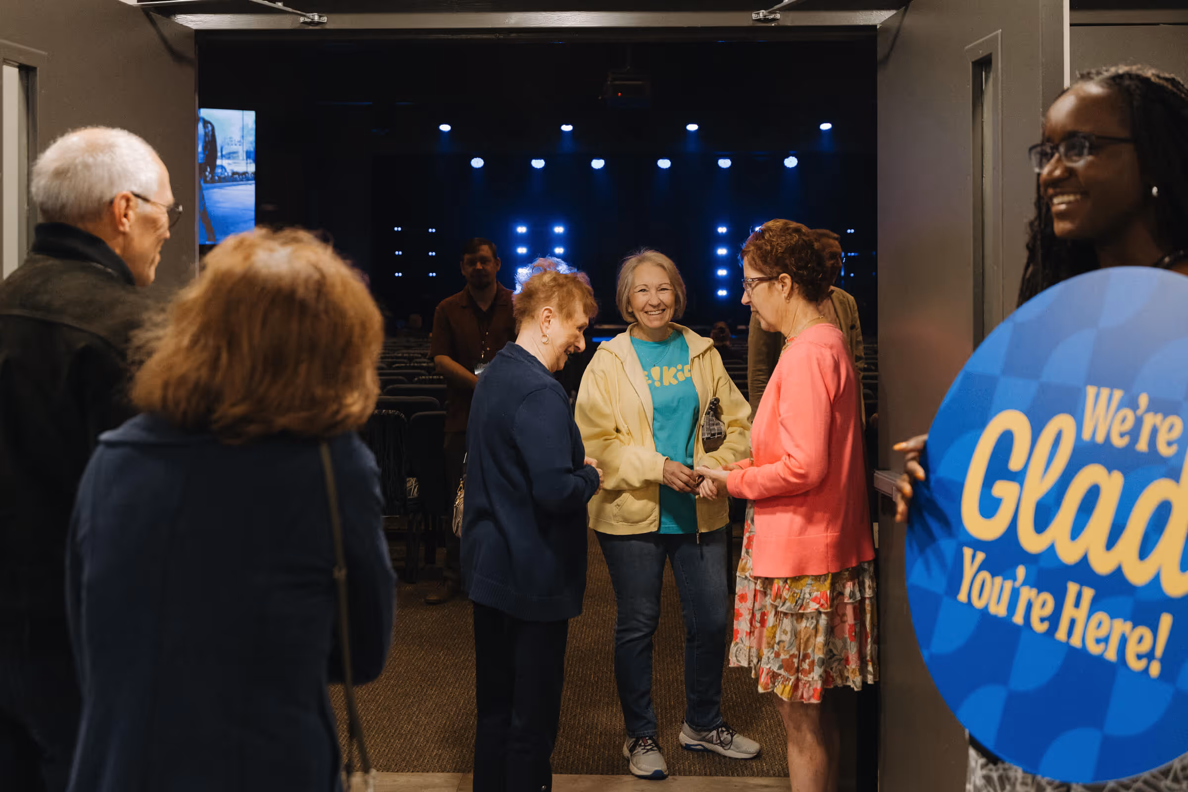 Group of people chatting and smiling after a service.