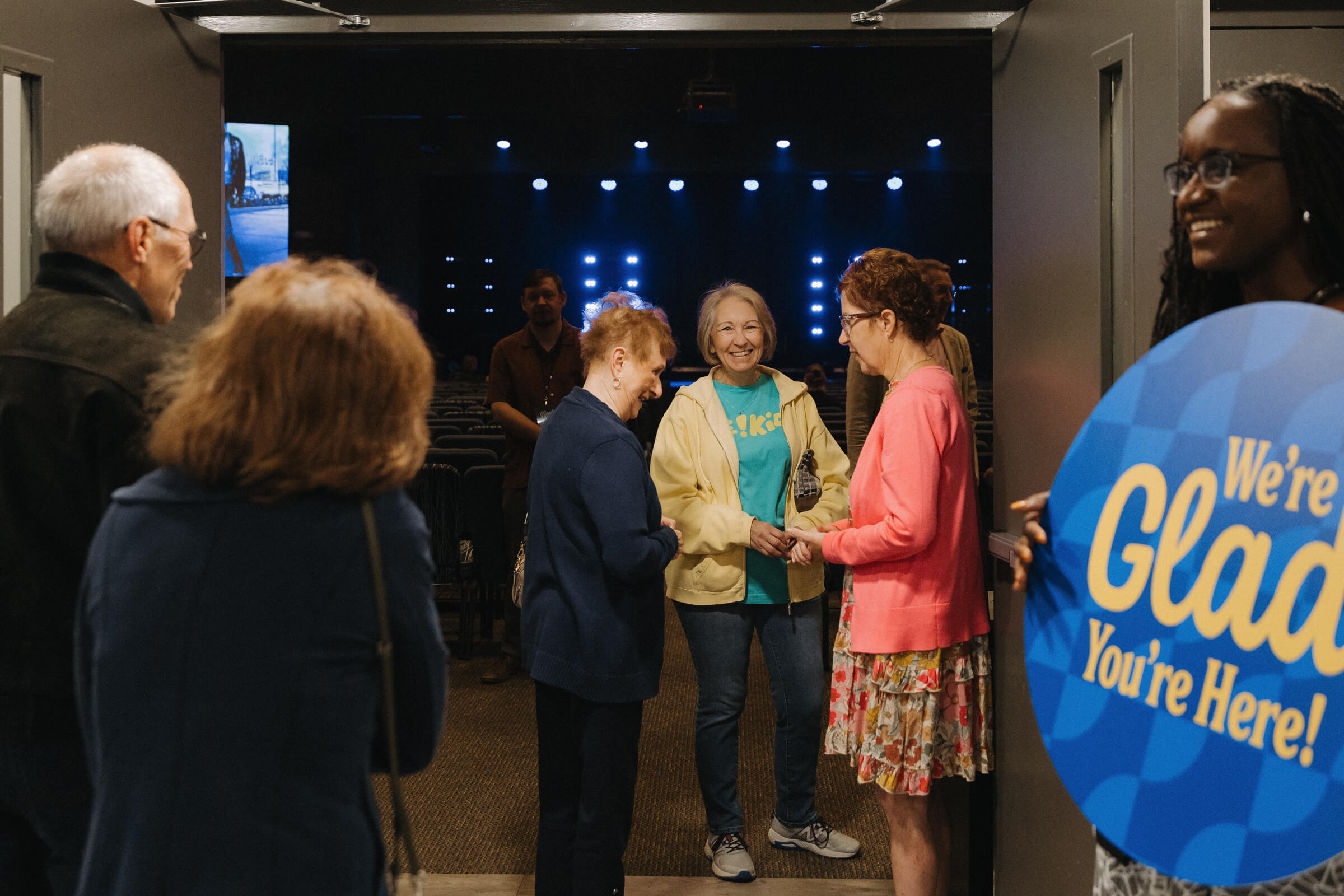 Group of people chatting and smiling after a service.