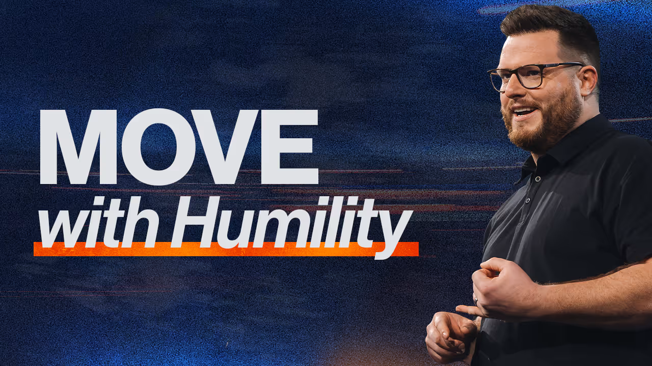 Smiling man with glasses and beard speaking against a dark blue background with the text 'MOVE with Humility'.