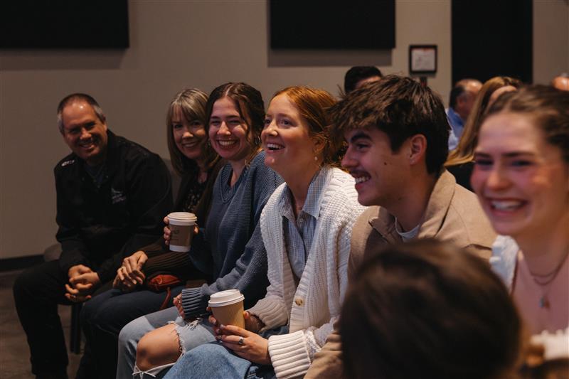 Young woman warmly greeting and embracing another person.