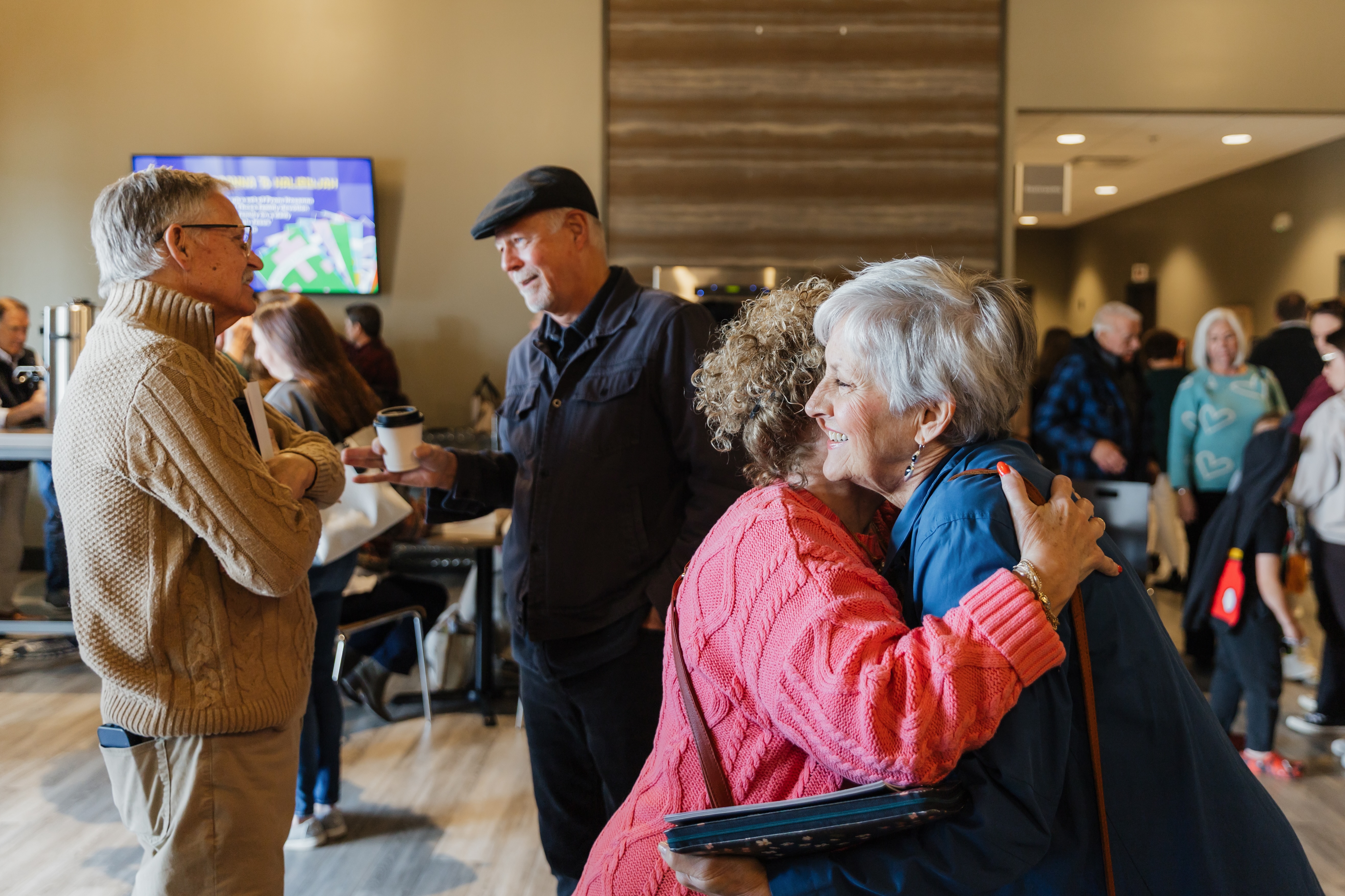 Group of people chatting and smiling after a service.