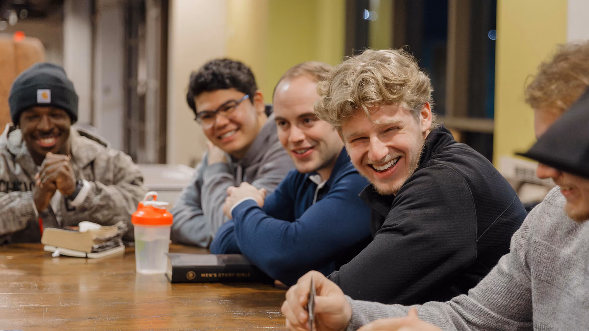 Three men sitting at a table, engaged in conversation.