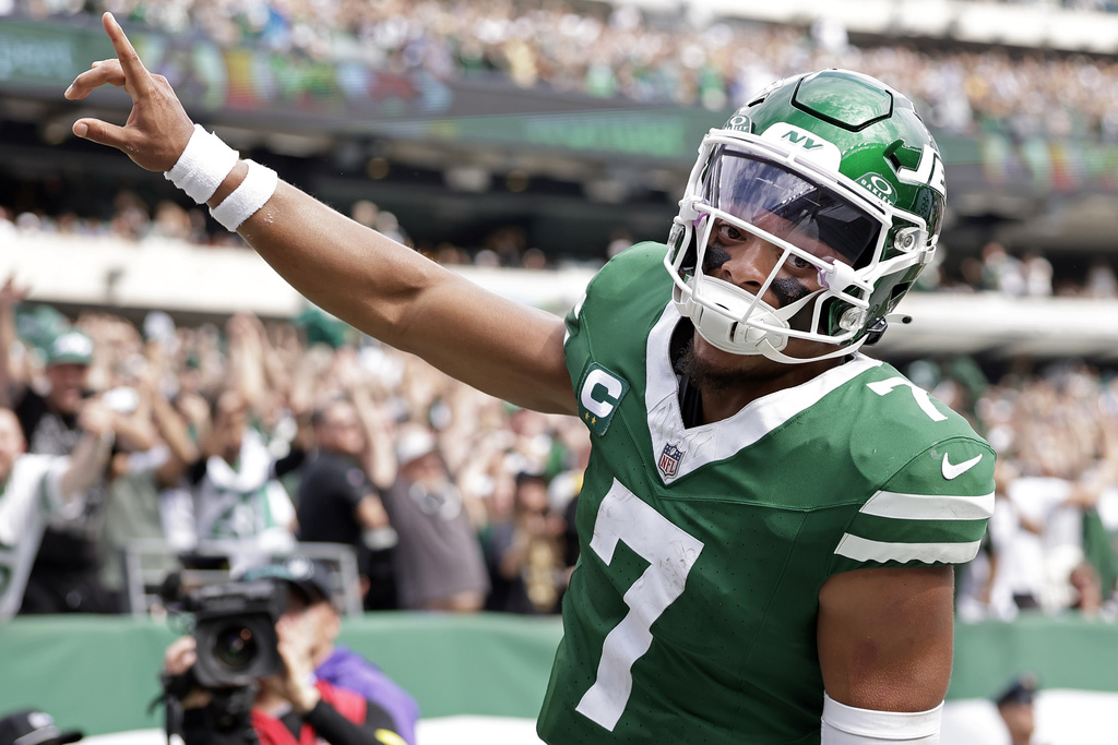Jets QB Justin Fields celebrates after scoring a TD in an NFL game.