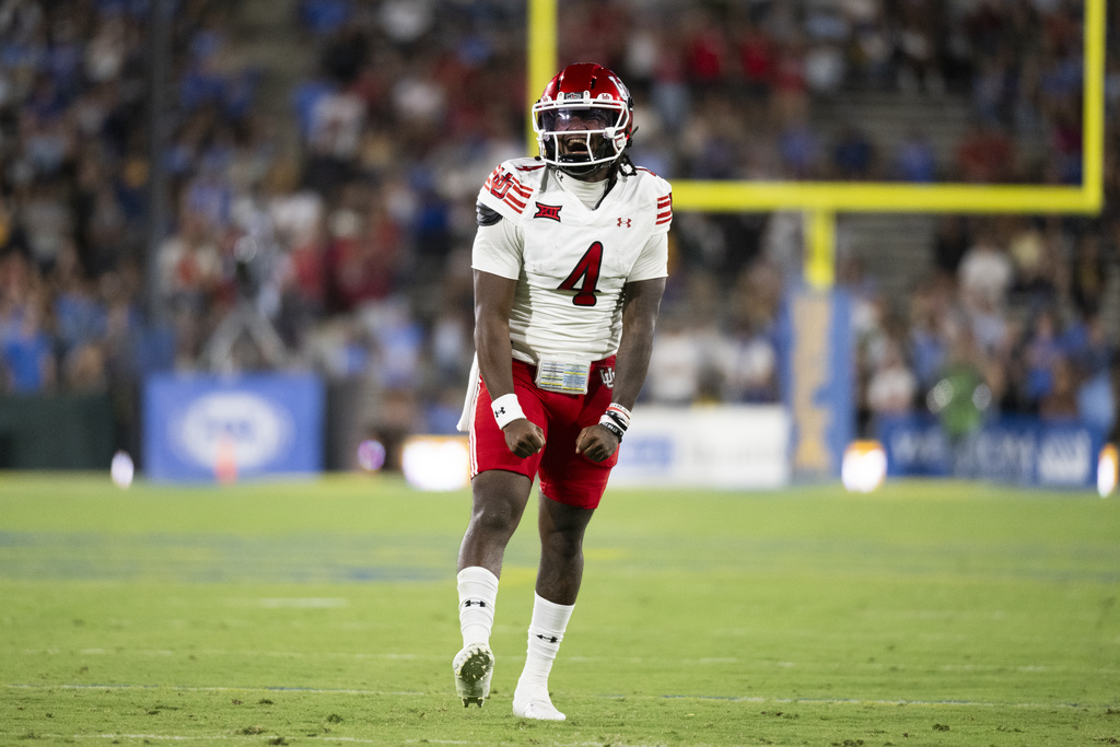 Utah QB Devon Dampier celebrates a TD in a college football game.