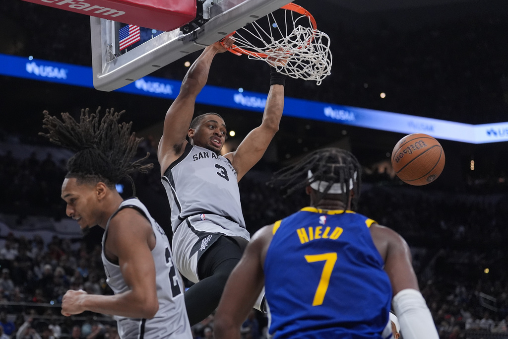 Spurs F Keldon Johnson dunks a basketball in an NBA game.