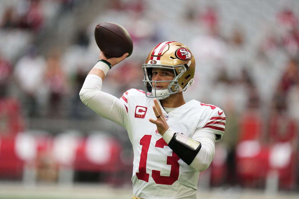 49ers QB Brock Purdy throws a football in an NFL game.