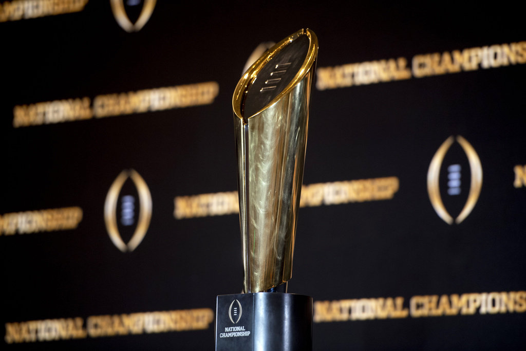 The college football championship trophy stands on a table. It is the trophy for the winner of the college football playoff.