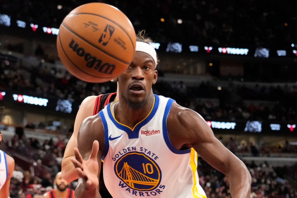 Warriors F Jimmy Butler chases a basketball in an NBA game.