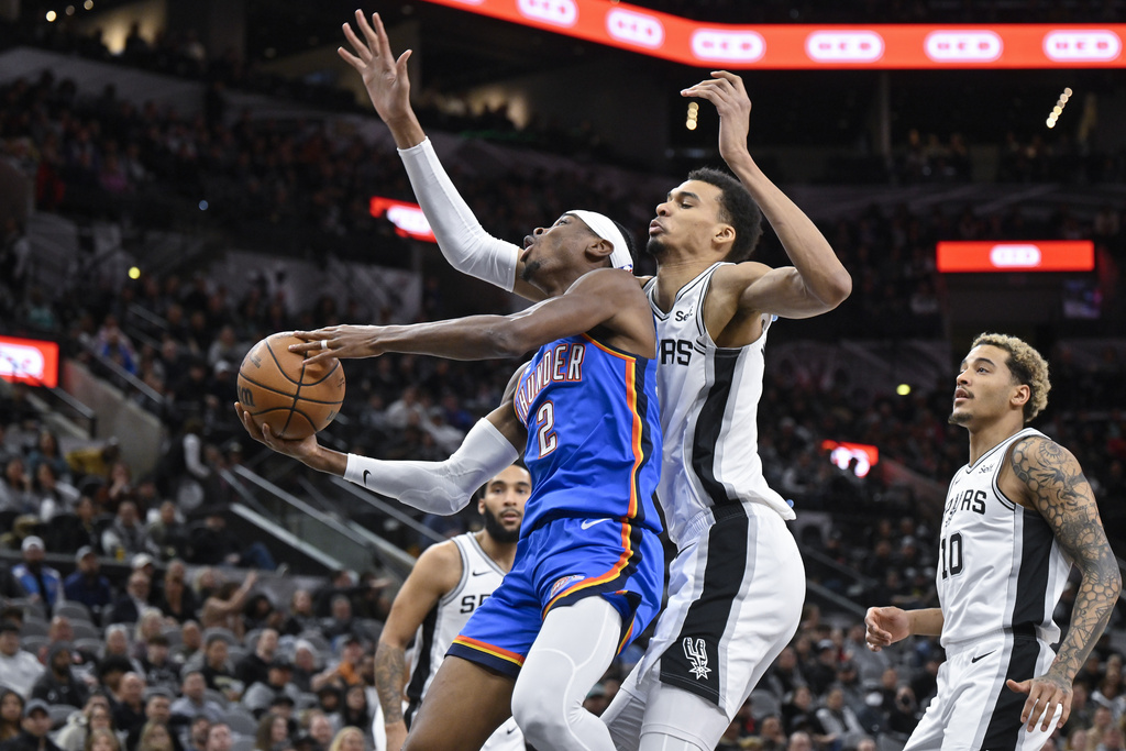 Spurs C Victor Wembanyama guards Thunder G Shai Gilgeous-Alexander in an NBA game.