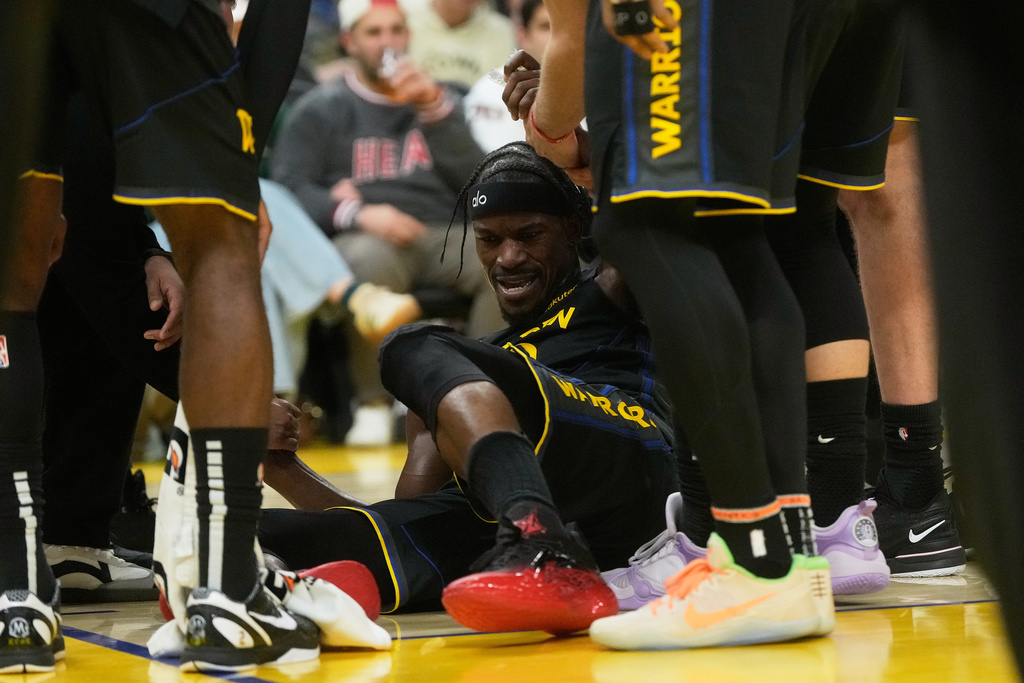 Warriors SF Jimmy Butler is helped by teammates after tearing his ACL in an NBA game.