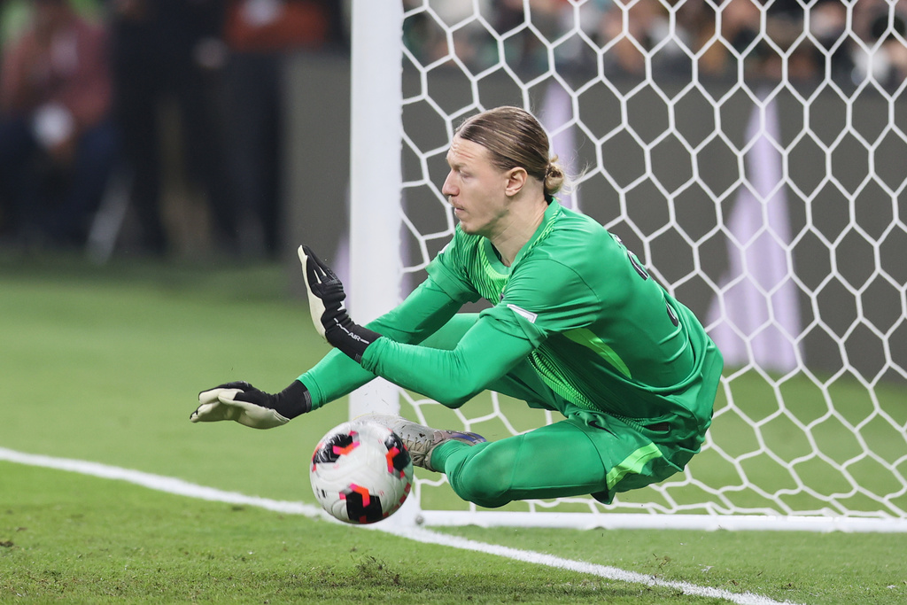 PSG GK Matvey Safonov saves a soccer ball in a Champions League match.
