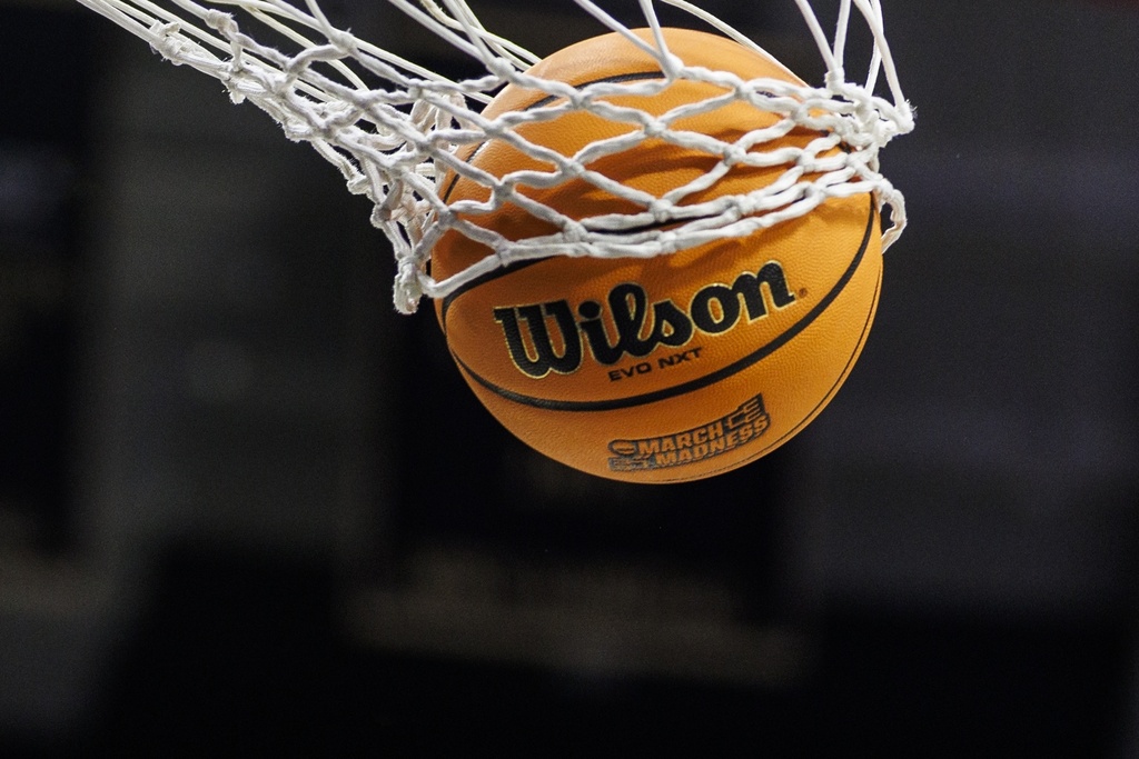 A basketball in the net with a March Madness logo during an NCAA Tournament game.
