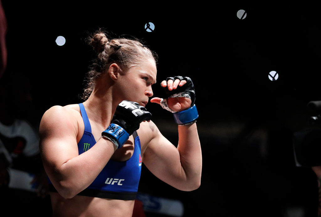 Ronda Rousey holds up her hands before her women's bantamweight championship MMA fight.