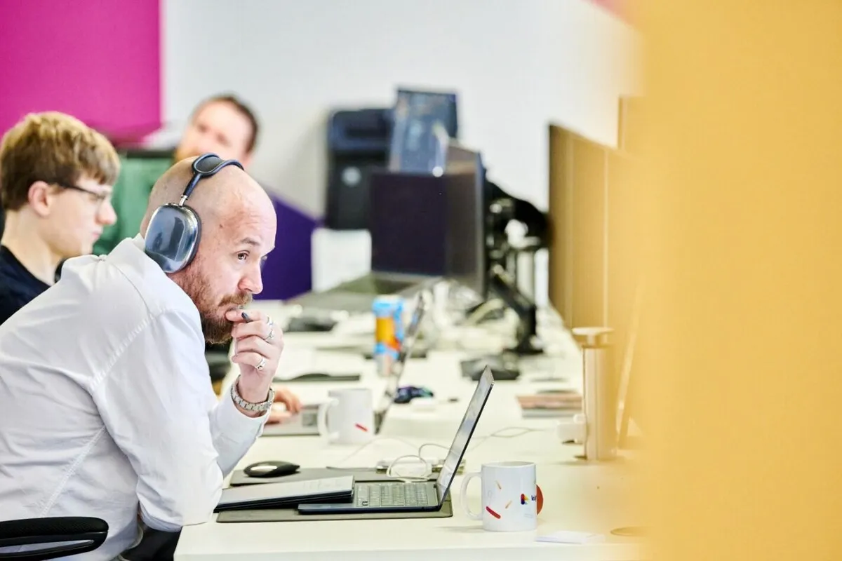 Author Steve Morland, sat at his desk, working at his computer with headphones on.