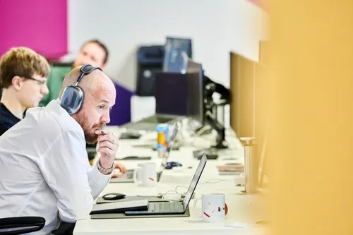 Author Steve Morland, sat at his desk, working at his computer with headphones on.