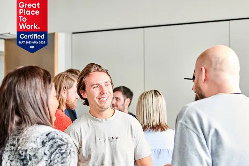 Colleagues engaged in a lively discussion about the Great Place to Work certification.