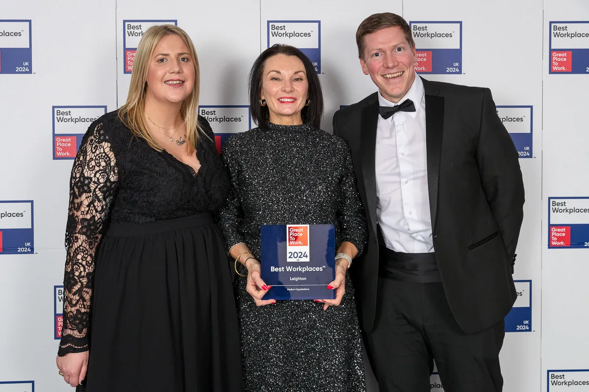 Leighton colleagues Holli Taylor, Claire Cundill and Andy Carr (L-R) holding their Best Workplaces UK Award in front of the Best Workplaces UK backdrop.