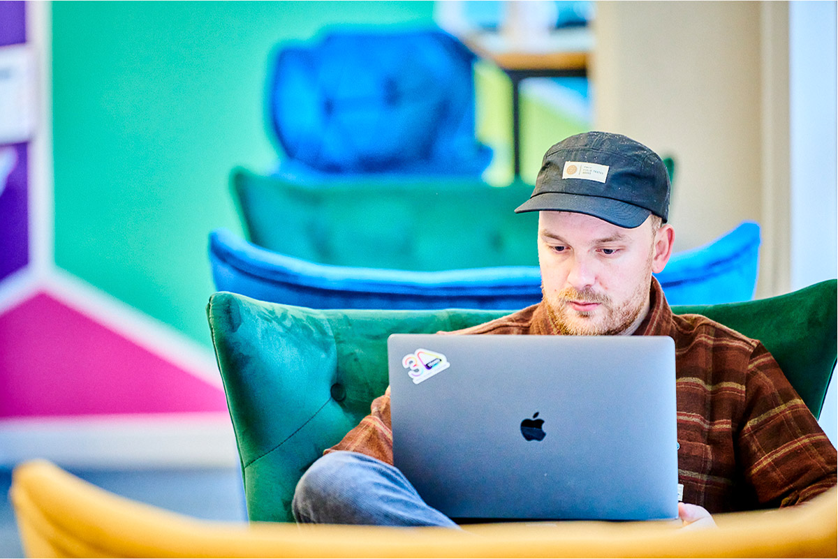 Colleague working on project against colourful backdrop in an office setting. 