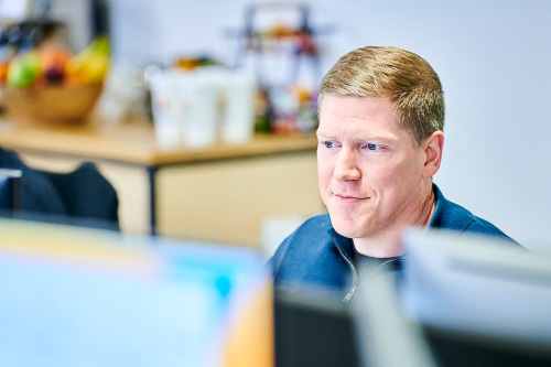Leighton Chief Financial Officer, Andy Carr sat working at a computer. 