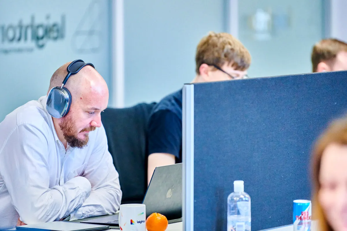 A Leighton colleague, in an office setting on a meeting wearing headphones.