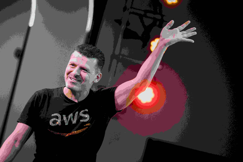 Matheus Guimaraes, Senior Developer Advocate at AWS, on stage at AWS North Community Conference, gesturing towards the screen