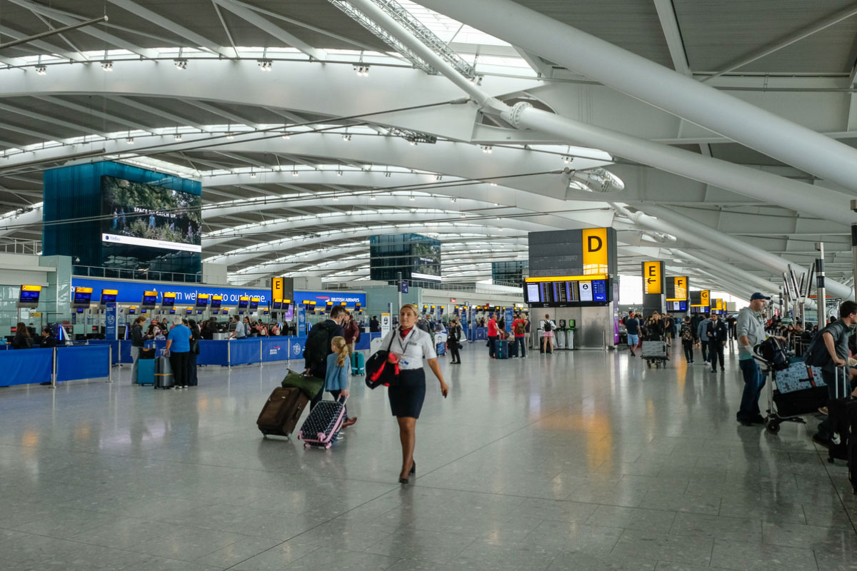 A member of British Airways cabin crew walking through a terminal at Heathrow Airport.