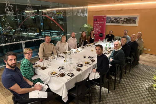 Attendees of the on:tech round table event, sat around a table looking at the camera. 