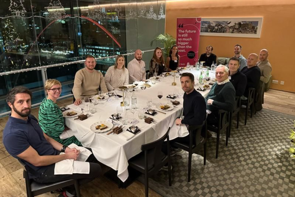 Attendees of the on:tech round table event, sat around a table looking at the camera.