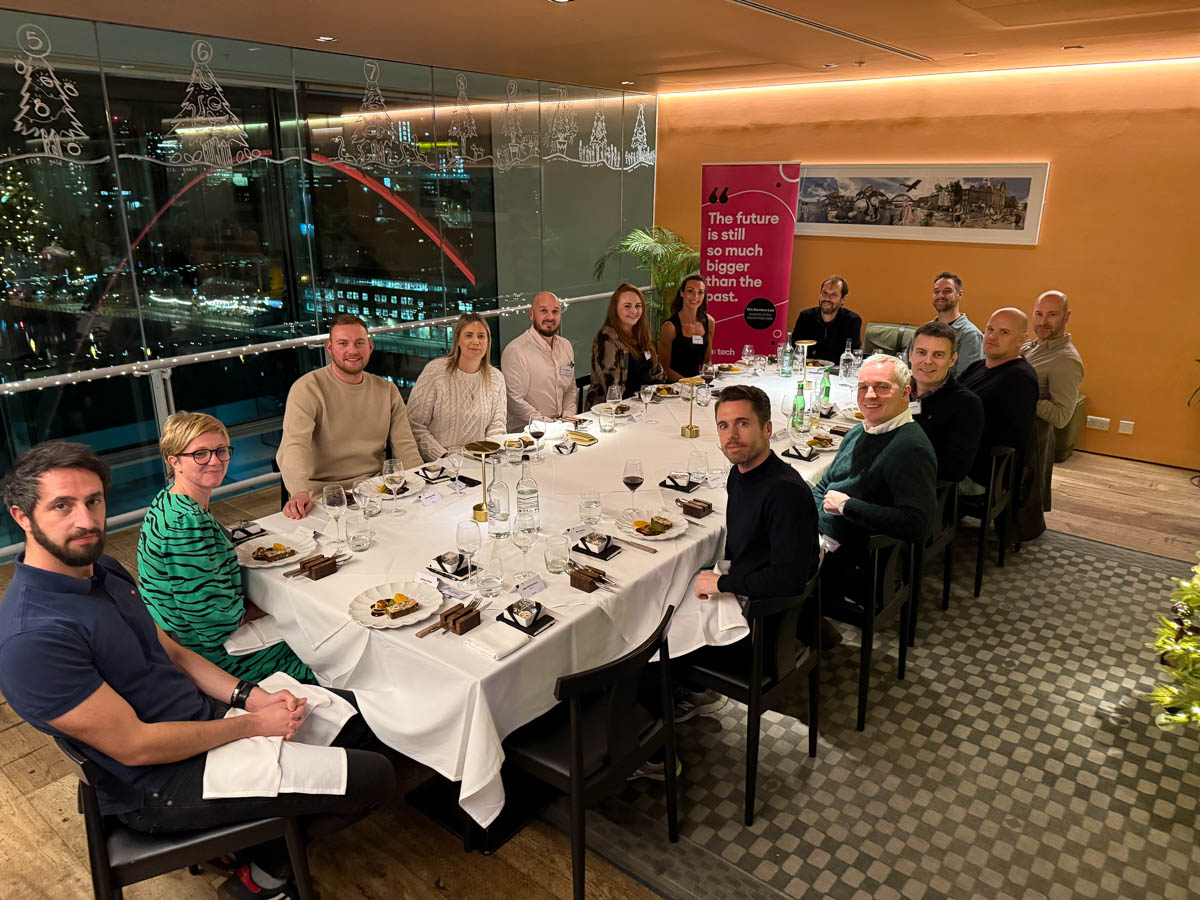 Attendees of the on:tech round table event, sat around a table looking at the camera. 