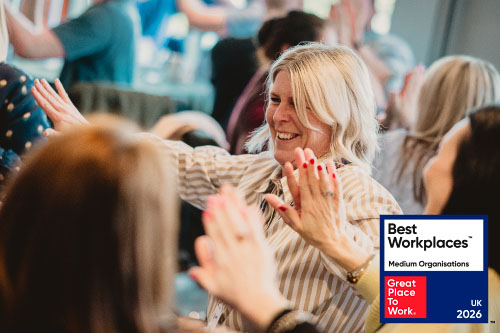 A Leighton colleague, joining hands and smiling with the UK's Best Workplaces logo overlaid. 
