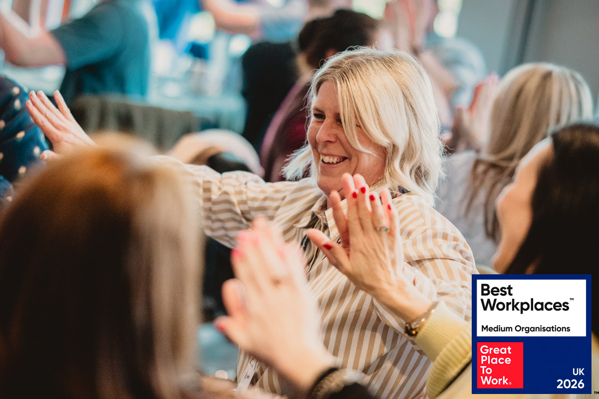 A Leighton colleague, joining hands and smiling with the UK's Best Workplaces logo overlaid. 