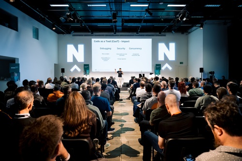 A speaker on stage delivering a talk at AWS North Community Conference 2026.